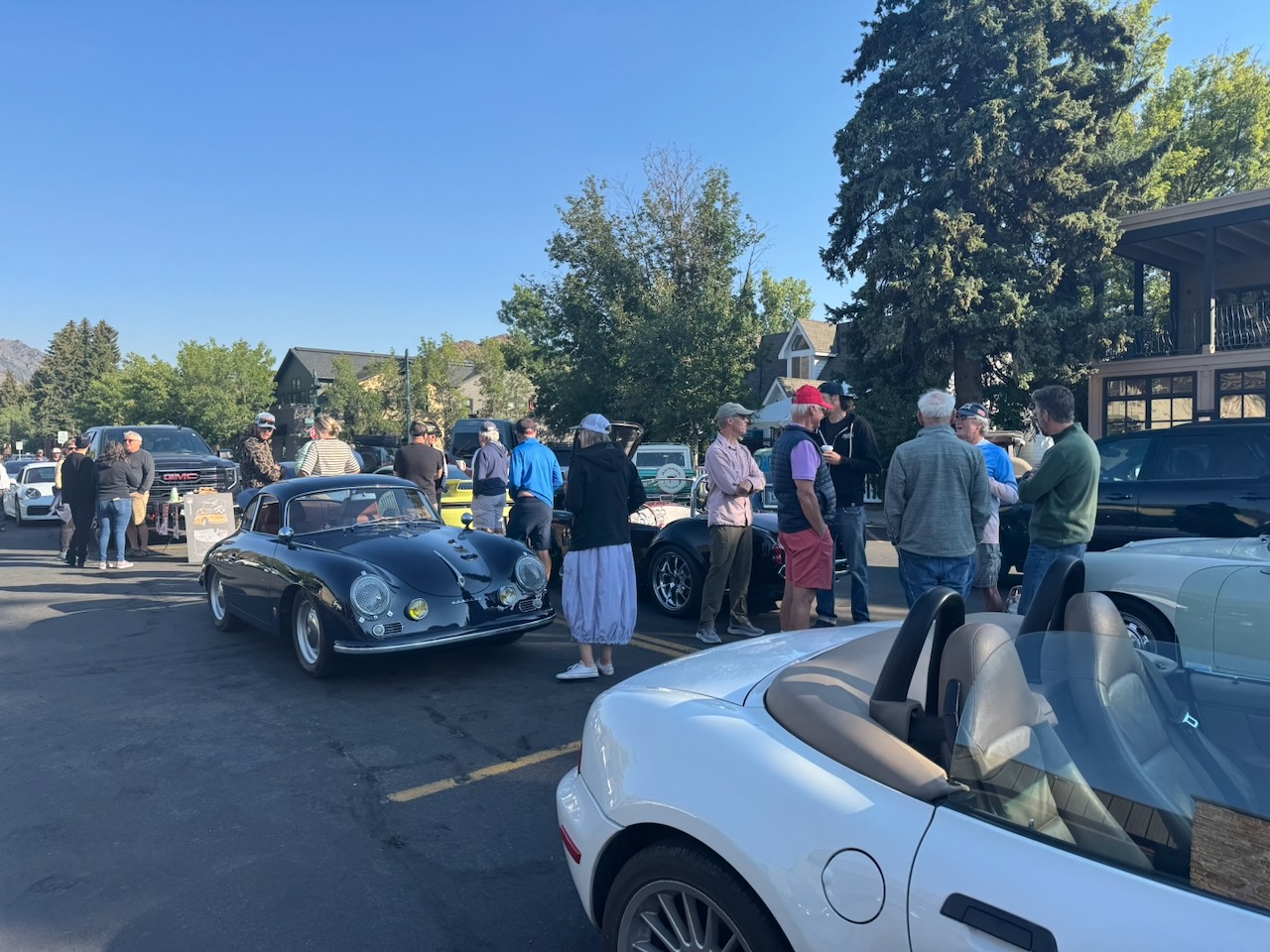 Enthusiasts chatting beside classic sports cars at Ketchum Cars and Coffee